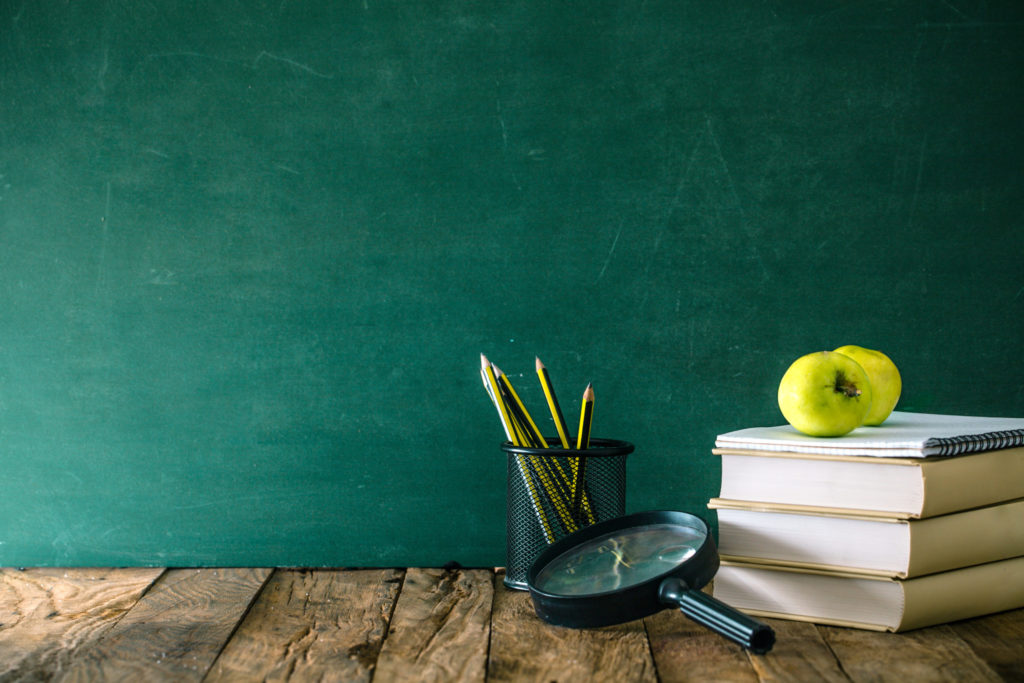 a couple of buckets with pens in them next to a chalkboard